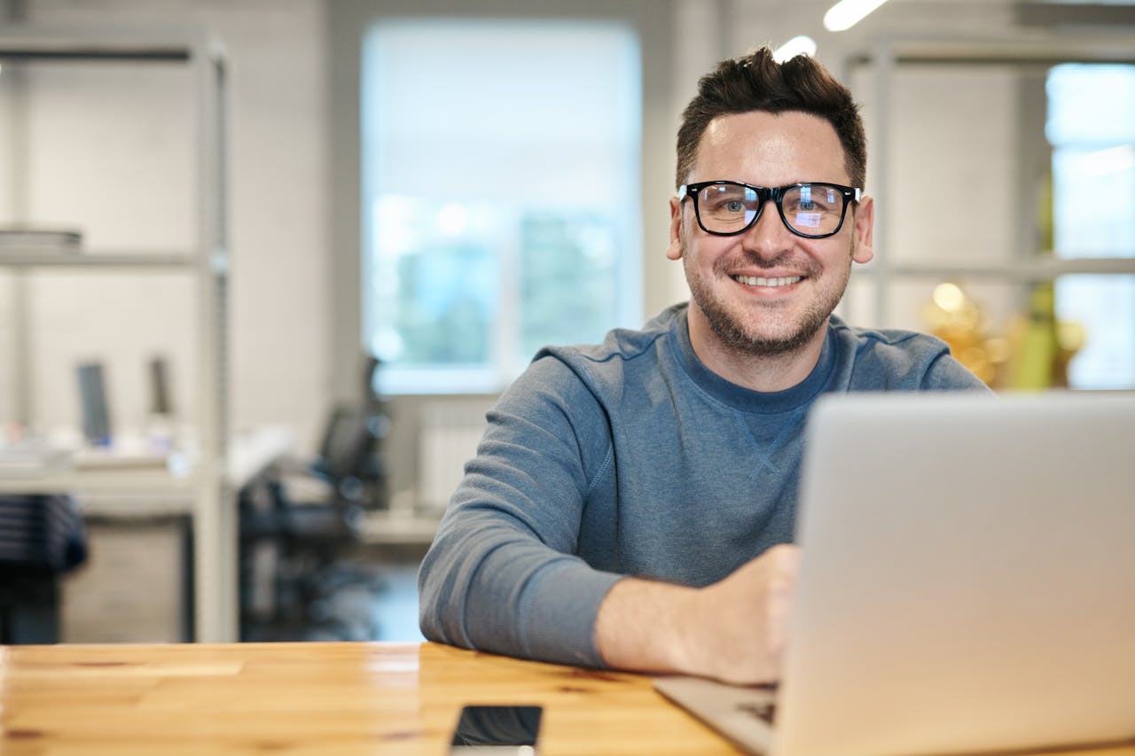 White male with glasses working on a laptop