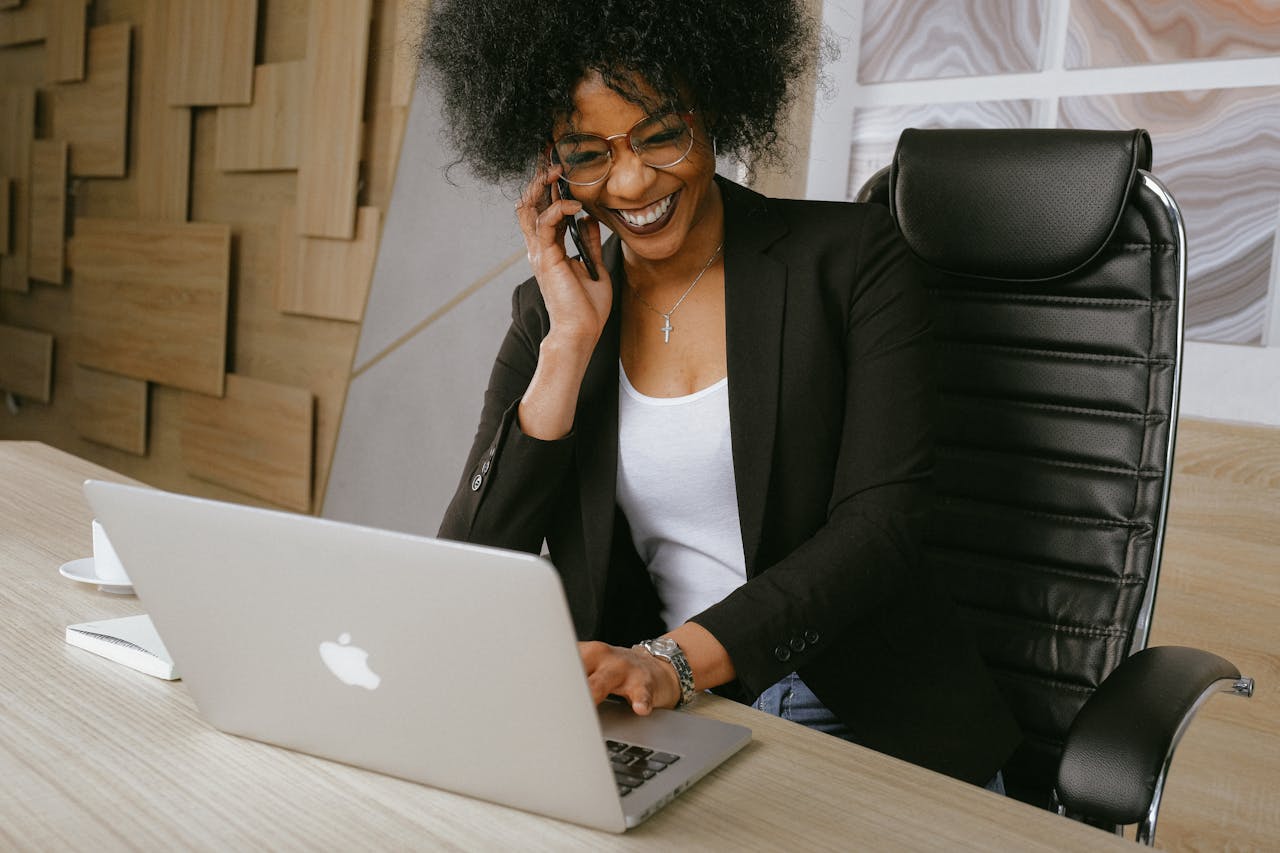 Black woman with glasses working on a laptop